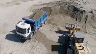 Toprak dolu bir kamyon. Sahne. İnşaat alanında toprak olan çöp kamyonunun en üst görüntüsü. İnşaat alanı ya da içi toprak dolu çöp kamyonları olan taş ocağı..