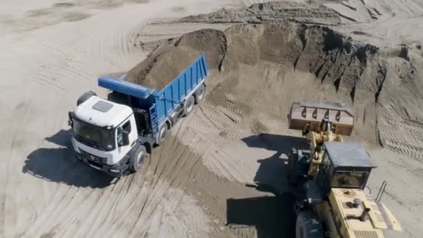 地球の完全なダンプトラック シーンか 建設現場のダンプトラックのトップビュー 地上に満ちたダンプ トラックが付いている建設現場か採石場 — ストック動画