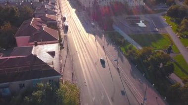 Güneşli bir günde arabalı güzel şehir yolu manzarası. Şarjör. Güzel evleri olan şehir otoyolu ve yazın sabah güneşi. Yolları ve yeşillikleri olan yaz kenti. 