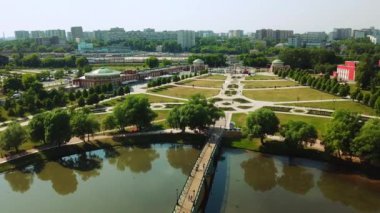 Küçük göleti olan bir şehir parkında çiçek ağaçları. Yaratıcı. Yeşil çalıların ve ağaçların havadan görünüşü, bir yaz günü şehir dekorasyonu.