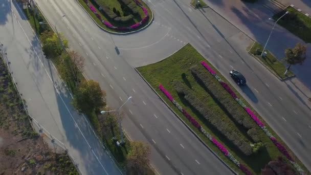 花と緑の芝生で装飾された市道を走行するドローンからの空中視界 クリップ 市街地の上を飛行する — ストック動画
