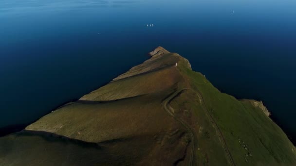 青い海の緑の山の岬のトップビュー ショット 夏の美しい青い海で美しい緑の帽子を撮影してください 海の長い山の岬 — ストック動画
