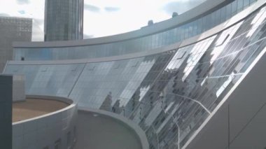  Mavi bulutlu bir arka planda cam cephede uçuyor. Stok görüntüleri. Şehir merkezindeki ofis binası.