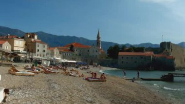 Güzel tatil köyü manzarası. Yaratıcı. Sahili gören manzara dalgalar, dağlar, anıtlar, konut binaları ve oteller. Yüksek kaliteli FullHD görüntüler