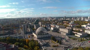 Sırbistan, Belgrad - 16 Haziran 2022: Mavi bulutlu bir gökyüzü arka planında bir yaz şehrinin havadan görünüşü. Stok görüntüleri. Yeşil caddelerin ve binaların üzerinde uçuyor