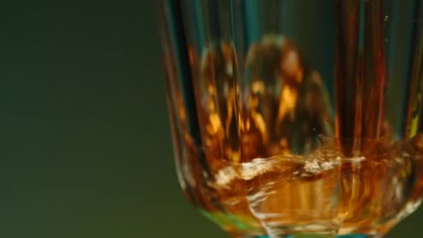 在透明的玻璃杯中倒入饮料的特写 库存夹 漂亮的杯子里塞满了酒精饮料 在与世隔绝的背景下 用杯子喝酒 — 图库视频影像