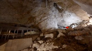 Aydınlanmış taş mağara duvarları. Başla. Taş oluşumları olan büyük kapalı bir mağara. Yeraltındaki kayalık mağaralara gezintiler. 