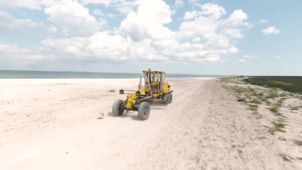 在蓝天的背景下 空中看到一辆拖拉机在沙滩上滑行 开枪了在海滩上驾驶的机器 — 图库视频影像