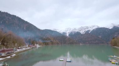 Turkuaz göl ve yeşil dağlarla nefes kesici bir manzara. Başla. Gök mavisi suda küçük yelkenli tekneler, seyahat konsepti.