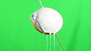 Modern sanat konsepti. Borsa klipsi. Yeşil duvar arka planına izole edilmiş beyaz sıvı boya ile doldurulan ahşap bir şişin üzerine limon meyvesi yakın çekim