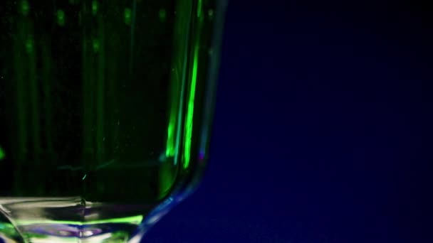 グラスでグリーンドリンクを閉じます ストッククリップ 夜のバーでアルコールと明るい緑の飲み物 バーやクラブでのアルコール飲料 — ストック動画