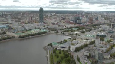 Sırbistan, Belgrad - 16 Haziran 2022: Mavi bulutlu bir gökyüzü arka planında bir yaz şehrinin havadan görünüşü. Stok görüntüleri. Yeşil caddelerin ve binaların üzerinde uçuyor