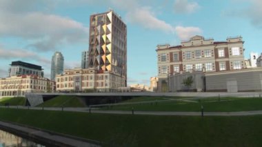 Güzel yaz manzarası. Stok görüntüleri. Nehrin yanındaki yüksek ofis binalarını, yeni cam ofisleri ve mavi gökyüzünü görebileceğiniz parlak bir şehir manzarası. Yüksek kalite 4k