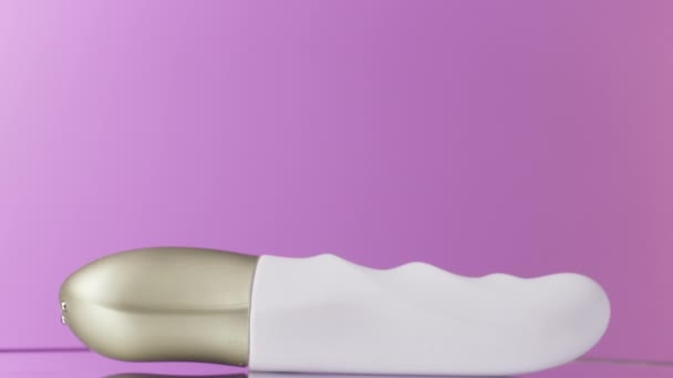 Jasne Fioletowe Tło Białym Wibratorem Akcja Kompaktowe Urządzenie Masażu Leżące — Wideo stockowe