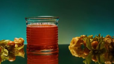 Masanın üzerindeki camı kırmızı soda ile kapat. Borsa klipsi. Böğürtlenlerle süslenmiş bar tezgahı bulanık ışık arka planında