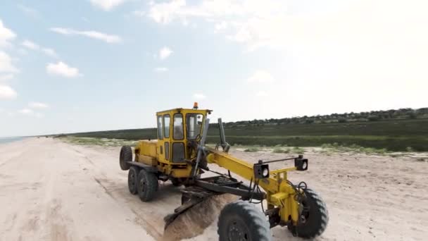 Желтый Трактор Выстрел Берегу Океана Работает Большой Трактор Который Ездит — стоковое видео
