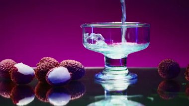 Liçi üzümlü güzel bir bar tezgahı. Borsa klipsi. Bardaki bardağa alkol kokteyli dökülüyor.