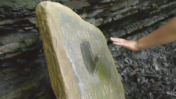 人は手の形をした後遺症のある石に手を貸す クリエイティブ 彼らは石の板に手を置きました 手は石の後ろに置かれました — ストック動画