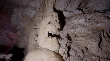 Büyük bir taş mağara. Hareket. İçinde büyük taşlar ve loş bir ışık olan gri bir zindan. Yüksek kalite 4k görüntü