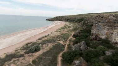 Helikopterden adaya manzara. Shot.Okyanus manzaralı küçük dalgalı ve üzerinde bitki örtüsü olan yüksek dağlı plaj manzarası. Yüksek kalite 4k görüntü