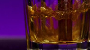 Bardağa köpüklü kola dök, kapat. Borsa klipsi. Renkli ışıklandırılmış arka planda şeffaf camda kola tozu.