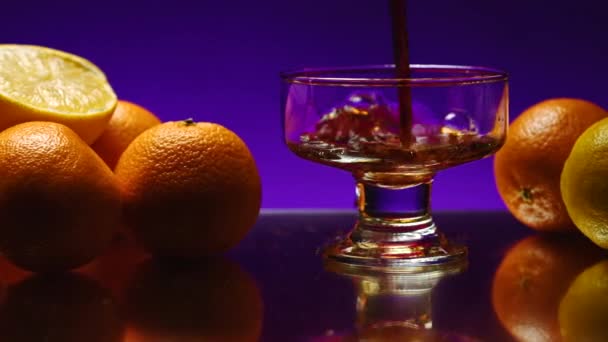 威士忌倒在玻璃杯里 放在彩色的墙壁背景上 库存夹 Orange躺在夜总会的桌子上 — 图库视频影像