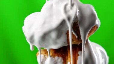 Çubuğun üzerindeki küçük kruvasanları kaplayan damlayan beyaz çikolata jölesi. Borsa klipsi. Pasta ürünleri yeşil krom anahtar arka planında izole 