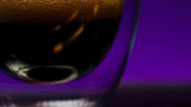 Bardaktaki soda köpükleri siyah bir duvara çarpıp renk değiştiriyor. Borsa klipsi. Çift dipli şeffaf bardakta meşrubat. 