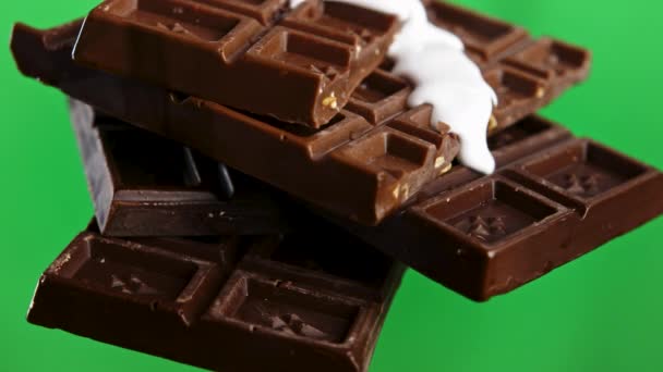 クロマキーグリーンウォールの背景に隔離された白い釉薬を排水するチョコレートバーの閉鎖 ストッククリップ ブラックチョコレートとホワイトグラス — ストック動画