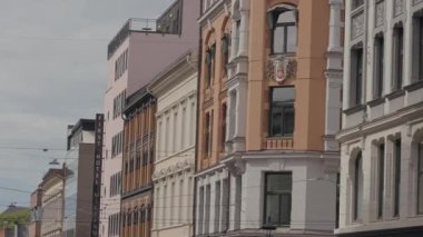 Birçok penceresi olan binaların görüntüsü. Başla. Bulutlu bir arka planda eski evleri olan şehir caddesi.