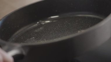 Yağ ile kızartma tavasının yakın çekim rotasyonu. Başla. Tavada petrol dağıtımı. Pişirmek için yeni kızartma tavasında ısıtma yağı. 