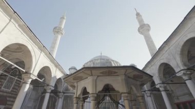 Türkiye, İstanbul - 14 Temmuz 2022: Minareleri tarihi eser olan güzel bir cami. Başla. Yüksek minareli caminin avlusunun alt manzarası. Güzel minareler berrak gökyüzüne yükselir