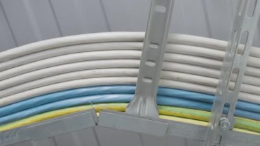 Metal raflardaki kablolar. Başla. Teknik kablolar birbirine bağlıdır. Elektrik kabloları metal bağlayıcılarda yatıyor.. 