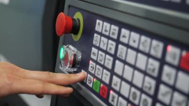 Makine kontrol panelinin düğmelerine yakın çekim. Medya. Üretim makinesini kontrol paneli kullanarak başlatın. Üretim makinelerini kontrol etmek için düğmeli panel. 
