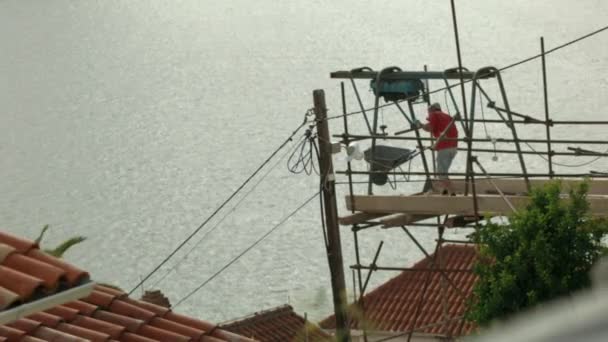 Evin Çatısında Inşaat Işçisi Var Yaratıcı Arka Planda Dalgalı Deniz — Stok video