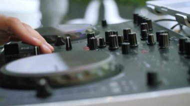 DJ konsolunda çalan adama yakın çekim. Medya. Adam düğmeleri müzik konsoluna çeviriyor. DJ diskoda yeni müzik konsolu çalıyor. 