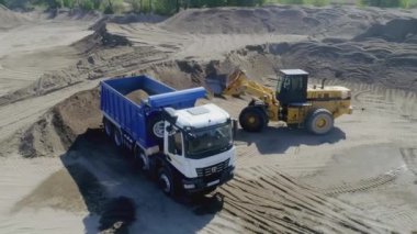 ABD, Arkansas - 28 Haziran 2022: Kum ocağı, inşaat endüstrisi için endüstriyel kum çıkarma. Sahne. Traktörler kum kamyonlarına kum yükler, maden kamyonu kum taşır