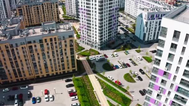 从直升机上俯瞰高楼 在商店附近的一个新地区 一条汽车和长椅的道路上 有一个巨大的彩色住宅区 高质量的4K镜头 — 图库视频影像