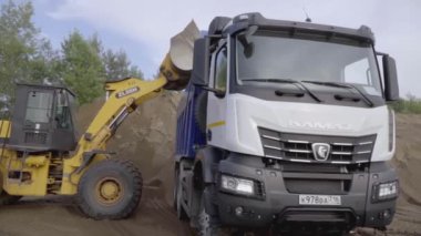 Berlin, Almanya - 20 Haziran 2022: Ağır makineler ile endüstriyel arka plan. Sahne. Kazı çalışmaları, toprak yükleme için bir kazıcı kullanılarak bir inşaat alanında gerçekleştiriliyor.