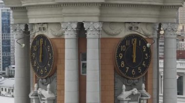 Helikopterden görüntü. Stok görüntüsü. Siyah saati ve şehrin büyük binaları olan turuncu bir yüksek kule arkadan görülebiliyor. Yüksek kalite 4k görüntü