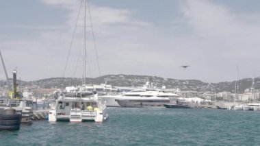 Demir atmış beyaz gemilerin görüntüsü. Aksiyon. Rüzgarla savrulan deniz, gemiler, tekneler, büyük yeşil dağlar ve mavi bir arka plan görülebilir. Yüksek kalite 4k görüntü