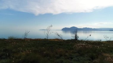 Sakin mavi su yüzeyindeki çayır manzarası göz kamaştırıcı. Vuruldu. Mavi gökyüzü sakin göle yansıyor. 