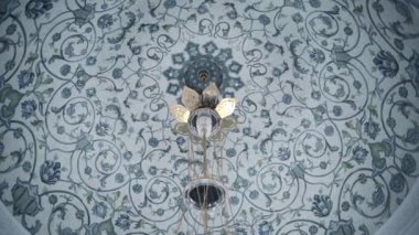 Mavi süslemeli beyaz tavanın alt görüntüsü. Sahne. Binanın içinde bir avize asılı.