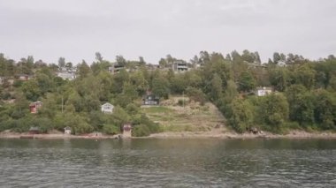 İnsansız hava aracının görüntüsü. Eylem. Etrafında uzun bir nehir manzarası olan uzun bir orman ve sıralı evler olan ve yerlilerin yaşadığı bir nehir manzarası. Yüksek kalite 4k görüntü