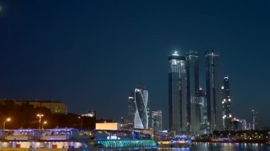 Nehrin yanında duran gökdelenlerin manzaralı gece manzarası. Başla. Işıklar ve fenerlerle aydınlatılan karanlık bir manzara. Büyük, yüksek binalar ve görebileceğiniz gibi.