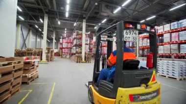 Sırbistan - Belgrad, 20 Eylül 2022: Malların toplanması ve toplanması. Yaratıcı. İşçiler tarafından özel küçük makineler üzerinde toplanan büyük paketlenmiş kutularla dolu büyük bir depo manzarası. Yüksek kalite