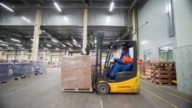 Sırbistan - Belgrad, 20 Eylül 2022: Malların toplanması ve toplanması. Yaratıcı. İşçiler tarafından özel küçük makineler üzerinde toplanan büyük paketlenmiş kutularla dolu büyük bir depo manzarası. Yüksek kalite