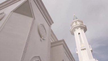 Gri gökyüzü ve beyaz taş kilisesiyle manzara. Sahne. Üzerinde küçük altın kubbeler olan güzel, uzun bir kilise manzarası. Yüksek kaliteli FullHD görüntüler