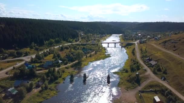 生活のための生態学的な場所の空想的な眺め クリップ 森に囲まれた川と橋のある平和な村 — ストック動画