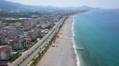 Okyanus kıyısı manzarası arabaların gittiği yerin yanında. Clip.Manzara plajın hemen yanında araçların ve konut evlerinin hareketli olduğu bir yol var. Yüksek kalite